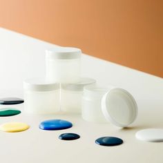 several white containers with different colored lids on a table