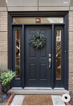 a black front door with a wreath on it