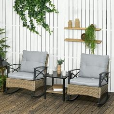 two wicker chairs sitting on top of a wooden floor next to a potted plant