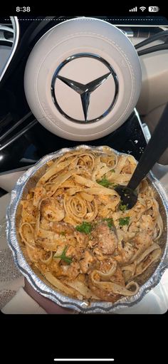 a close up of a plate of food on a table with a steering wheel in the background