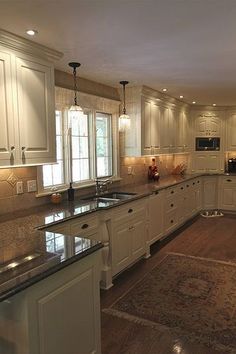 a large kitchen with white cabinets and granite counter tops