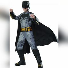 a young boy dressed in a batman costume poses for the camera with his fist raised