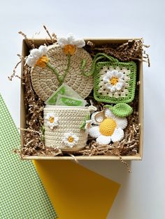 an open box with crocheted items in it on a yellow and green table