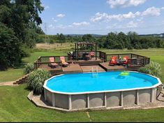 an above ground swimming pool surrounded by lawn chairs and decking around the pool area