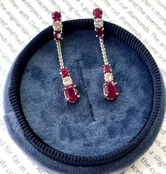 Show off your elegant style with these stunning Vintage 14K White Gold Ruby & Diamond Dangling Earrings. The dazzling cranberry colored rubies catch the light beautifully, while the sparkling diamonds provide the perfect contrast and added elegance. These handcrafted earrings feature a vintage design with the rubies and diamonds dangling delicately. With their timeless beauty and sophisticated look, these ruby and diamond earrings are sure to turn heads and stand out at any special occasion. Make these gorgeous earrings your go-to accessory for a glamorous touch to any outfit. Treat yourself or someone special to these one-of-a-kind vintage earrings today! Metal: 14K White Gold Weight: 3.6 grams (without back) Ruby: Approximately 0.75 cts Diamond:Approximately 0.35 cts Measurement: 1.4 inc Diamond Dangling Earrings, Ruby And Diamond Earrings, Rubies And Diamonds, Estate Diamond Jewelry, Cranberry Color, Ruby Diamond, Dangling Earrings, Handcrafted Earrings, Gorgeous Earrings