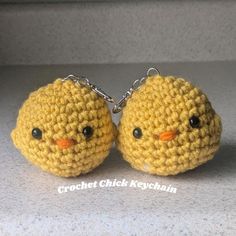 two yellow crocheted chicks with black eyes sitting on top of a counter next to each other