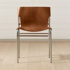 a brown leather chair sitting on top of a hard wood floor