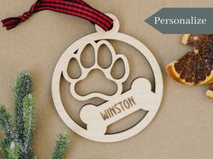 personalized ornament with dog's paw and bone on it next to orange slices