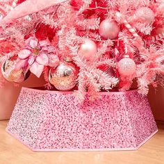 a pink christmas tree decorated with ornaments