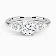 a white gold engagement ring with an oval cut diamond surrounded by small round brilliant diamonds