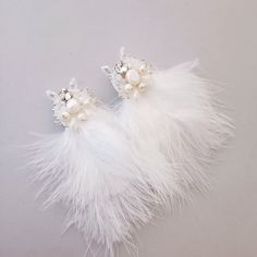 Elevate your bridal ensemble with these exquisite boho feather earrings, designed to add a touch of ethereal charm to your special day. Crafted with meticulous attention to detail, each earring features delicate white feathers adorned with shimmering crystals and lustrous pearls, creating a graceful and timeless aesthetic. Features: Elegant Design: These feather earrings exude an air of elegance and sophistication, perfect for the modern bride seeking a bohemian-inspired look. Versatile Closure Bohemian Bridal Earrings For Wedding, White Feather Dangle Earrings, Elegant Feather Dangle Jewelry, Elegant Silver Feather Earrings, Elegant Feather Dangle Earrings, Elegant Dangle Feather Earrings, Elegant Dangle Earrings With Feathers, Handmade Pearl White Bridal Earrings For Wedding, White Bohemian Bridal Earrings For Wedding