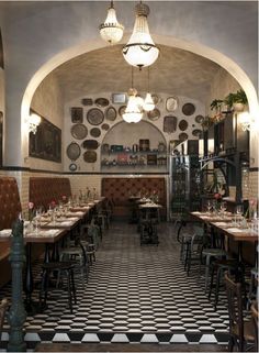 the inside of a restaurant with checkered flooring and chandeliers hanging from the ceiling