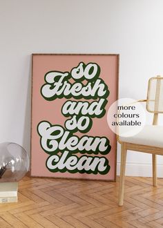 a pink and green poster sitting on top of a wooden floor next to a chair