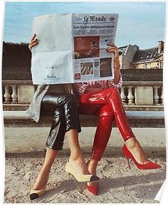 a woman sitting on a bench reading a newspaper while wearing red pants and high heels