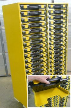 a large yellow storage rack filled with lots of drawers next to a man's hand