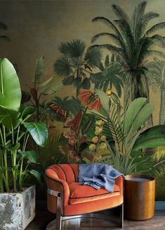 an orange chair sitting next to a potted plant