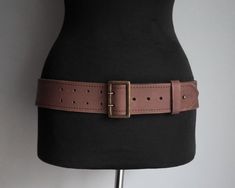 This belt is an item from the '90s. It is made of muted dark brown thick leather. It has a side ring. It fastens with rectangular brass buckle with double needle. The tip of the belt can be secured with a brass pin. Size EUR 92 / US 36 It is adjustable, 5 holes. Fits waist or low waist from 87cm / 34.2" at the first hole to 97cm / 38.2" at the last hole. Width 5.2 cm / 2.05" The belt is in good condition, it shows few wear marks, nothing major. Similar items https://www.etsy.com/shop/ForgottenSp Classic Brown Belt With Brass Hardware, Brown Belt With Brass Hardware For Everyday, Brown Belt With Antique Buckle For Everyday Use, Vintage Leather Belt Rectangular Shape, Vintage Belts With Rectangular Antique Buckle, Vintage Belt With Antique Buckle, Vintage Rectangular Leather Belt Buckles, Brown Rectangular Belt For Everyday Use, Classic Brown Rectangular Belt Buckles