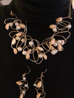 "\"BEACH PARTY\" Wire is twisted into an avant-garde maze, strung with 8 mm pearls and smaller size cowrie shells. Select gold or silver. The necklace measures 18 inches with chains attached to include a lobster claw clasp  for closing and adjusting to a smaller size. If 18 inches is too small, please message me for a longer neckline. Pierce earrings hang to 2 inches, and  are a fine match, made with smaller pearls and smaller cowrie shells. A beautiful expression of summer! Jewelry will arrive Bohemian Pearl Charm Party Jewelry, Bohemian Pearl Necklace For Party, Adjustable Gold Pearl Necklace For Party, Bohemian Pearl Jewelry For Party, Elegant Beaded Spiral Jewelry, Unique Pearl Drop Jewelry For Party, Party Wire Wrapped Pearl Jewelry, Costume Jewelry Pearl Drop For Party, Party Costume Jewelry With Pearl Drop