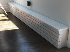 a white bench sitting on top of a hard wood floor