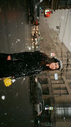 a woman is standing in the rain with her head down and looking at the camera