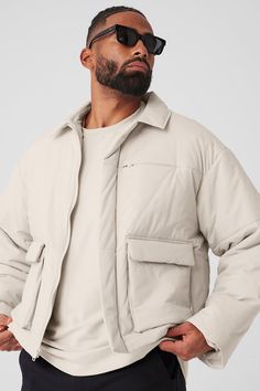 A fresh take on your favorite puffer, the Voyage Utility Cargo Jacket has a sharp collar, a zippered breast pocket and oversized front flap pockets that bring the cool factor. The silhouette is lightly filled (the perfect weight for brisk weather) with subtle quilting. The boxy, slightly oversized fit layers nicely over tees and hoodies—pair with the matching Voyage Utility Cargo Pants for a solid set. Alo Yoga Long Sleeve Winter Puffer Jacket, Alo Yoga Long Sleeve Puffer Jacket For Fall, Alo Yoga Fall Puffer Outerwear, Urban Puffer Jacket With Padded Collar, Urban Puffer Jacket With Pockets For Streetwear, Urban Style Puffer Jacket For Streetwear, Alo Yoga Winter Streetwear Outerwear, Alo Yoga Winter Puffer Jacket, Urban Oversized Outerwear With Side Pockets