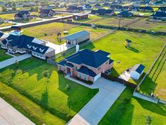 an aerial view of a large home in the middle of a grassy area with lots of houses