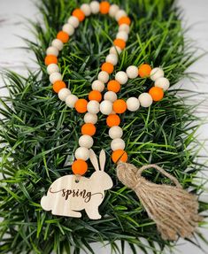 an orange and white beaded necklace with the word spring on it