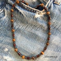 This beautiful tiger eye beads necklace is perfect for surf lovers who want to add a touch of natural beauty to their style. The warm and earthy tones of the tiger eye beads evoke a sense of calm and grounding, making it an ideal accessory for those who enjoy spending time by the ocean. Handcrafted with care and attention to detail, this necklace is a unique piece that will complement any beach-inspired outfit. Whether you're hitting the waves or simply soaking up the sun, this necklace is sure Casual Brown Necklaces For The Beach, Casual Brown Necklace For Beach, Casual Brown Beaded Necklace For Beach, Casual Brown Beaded Necklace For The Beach, Artisan Brown Beaded Necklace For Beach, Brown Polished Beads For Beach, Casual Brown Beaded Necklaces, Rustic Brown Gemstone Bead Necklaces, Beach Necklace With Brown Round Beads