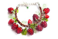 a bracelet with berries and leaves on it