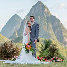 a bride and groom posing for a photo in front of the mountains at their wedding