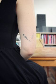 a woman with a small tattoo on her left arm and the back of her shoulder