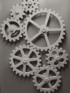 three gears are shown on the wall in this black and white photo, which is part of an art installation