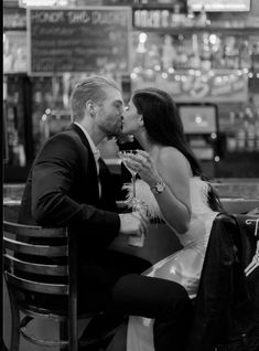 a man and woman sitting at a table kissing