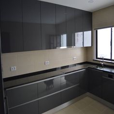 an empty kitchen with stainless steel cabinets and black counter tops, along with a window that looks out onto the street