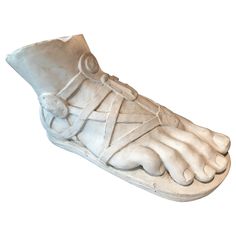 a white statue of a foot with laces on it