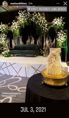 a wedding cake sitting on top of a table next to a black and white backdrop