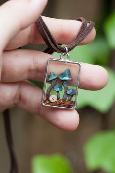 Mushrooms pendant, hand sculpted and painted, encapsulated in resin with a cute snail. This nature inspired necklace is a unique piece, no molds.  Double suede cord closes with chain to adjust length.  SPECIFICATIONS: * Materials: epoxi clay, UV resin, suede cord * Dimensions: rectangle pendant 3x2 cm * Length: 52cm cord, 4cm chain PROCESSING TIME take 2-5 business days. *Shipped with worldwide EXPRESS SAFE SHIPMENT (2-5 days of delivery approximately, depending on the area) *TRACKING NUMBER INC Whimsical Silver Resin Jewelry, Handmade Adjustable Whimsical Charm Necklace, Bohemian Jewelry With Pressed Flowers In Resin, Hand Painted Nature-inspired Necklace For Gift, Nature-inspired Hand Painted Necklace For Gift, Nature-inspired Hand Painted Jewelry For Gifts, Whimsical Mushroom Design Jewelry Gift, Handmade Fairycore Necklace For Gift, Whimsical Adjustable Mushroom Design Jewelry