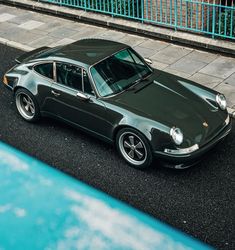 a dark green porsche parked on the street