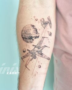 a man with a tattoo on his arm that has an airplane and planets in it