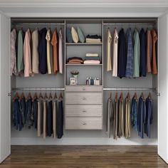 an open closet with clothes hanging on the shelves and drawers, along with other items