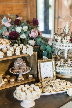 a table topped with lots of cupcakes next to a wooden box filled with pastries