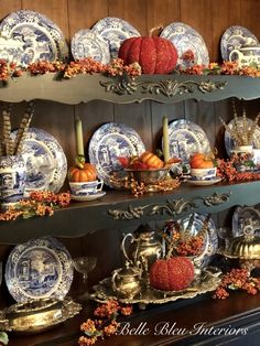 an assortment of blue and white china on display in a room with wood paneling