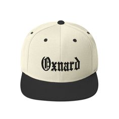 "Oxnard City Cap Snapback Hat This hat is structured with a classic fit, flat brim, and full buckram. The adjustable snap closure makes it a comfortable, one-size-fits-most hat.  * 80% acrylic, 20% wool (green camo is 60% cotton, 40% polyester) * Structured, 6-panel, high-profile * Plastic snap closure * Green under visor * Head circumference: 21 ⅝\" - 23 ⅝\" (54.9 cm to 60 cm)" Old English Lettering, Butterfly Man, English Classic, Miami City, Snapback Caps, Chicago City, Black And White Fabric, Streetwear Sneakers, Natural Cream