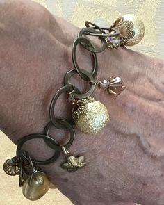 a close up of a person's arm wearing a bracelet with charms on it