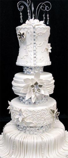 a three tiered wedding cake with white frosting and bows on the top layer