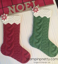 two christmas stockings are hanging on the wall next to a sign that says noff