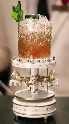 a tall cake with sprinkles on top of it sitting on a table