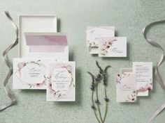 the wedding stationery is laid out with flowers and ribbons