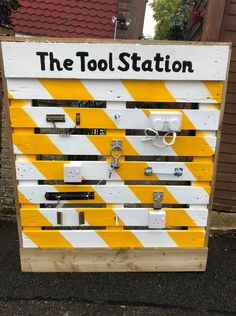 the tool station sign is made out of pallet wood and has yellow and white stripes on it