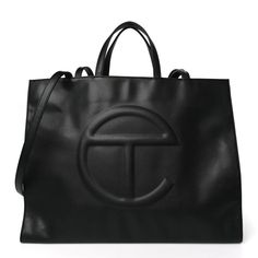 This is an authentic TELFAR Vegan Leather Large Shopping Bag in Black.This is a tote crafted of synthetic leather in black with the iconic raised Telfar logo at the front. The shoulder bag has short top handles, and two long shoulder straps. The top secures with a magnet snap and opens toa black fabric-lined interior with a zippered pocket. Telfar Bags Large, Telfar Tote Bag, Telfar Logo, Telfar Shopping Bag, Telfar Bags, Clothing Ideas, Synthetic Leather, Black Fabric, Large Bags